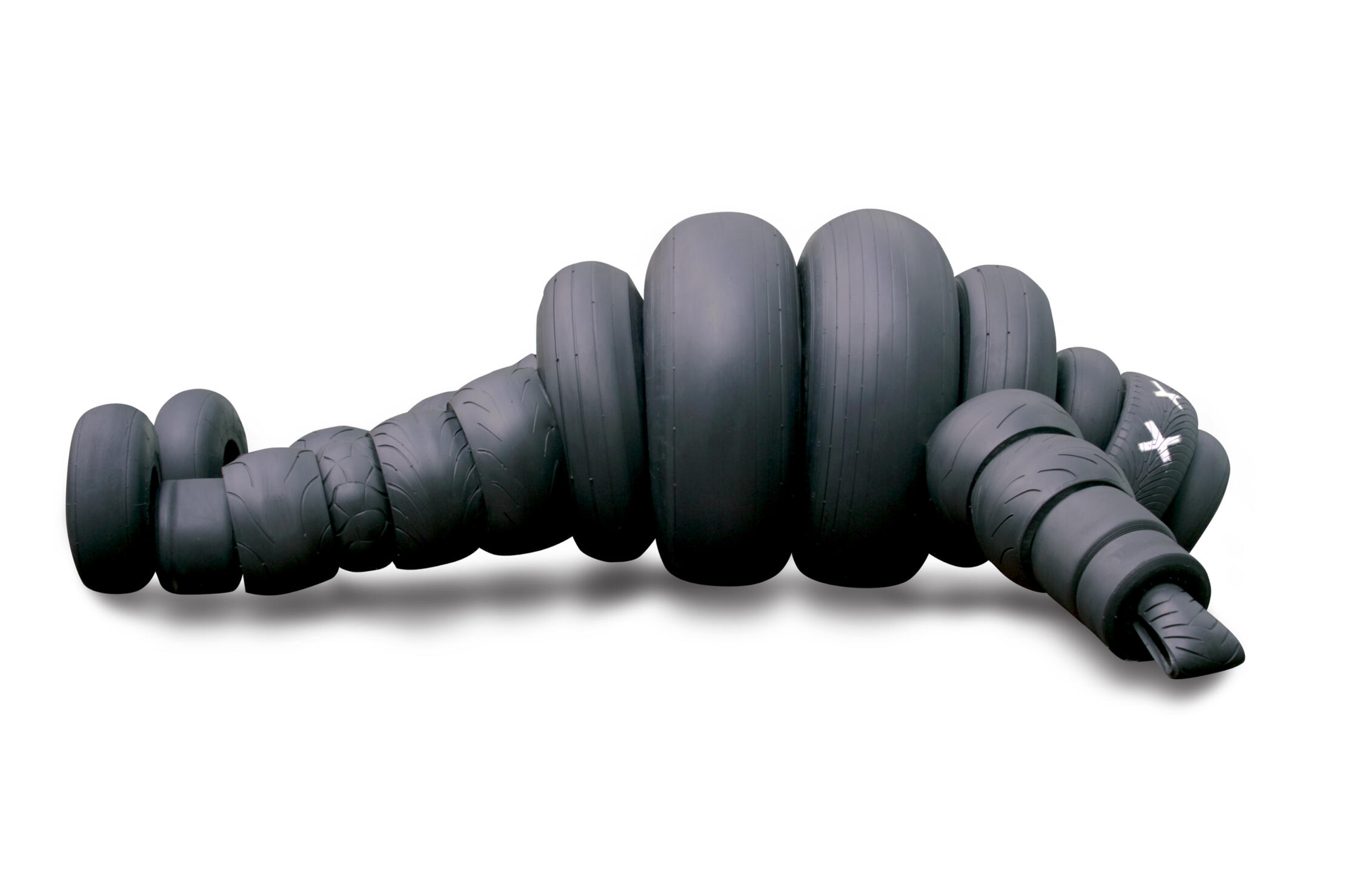 RUEDA SUELTA - sculpture Black sculptural form resembling stacked tires on a white background.